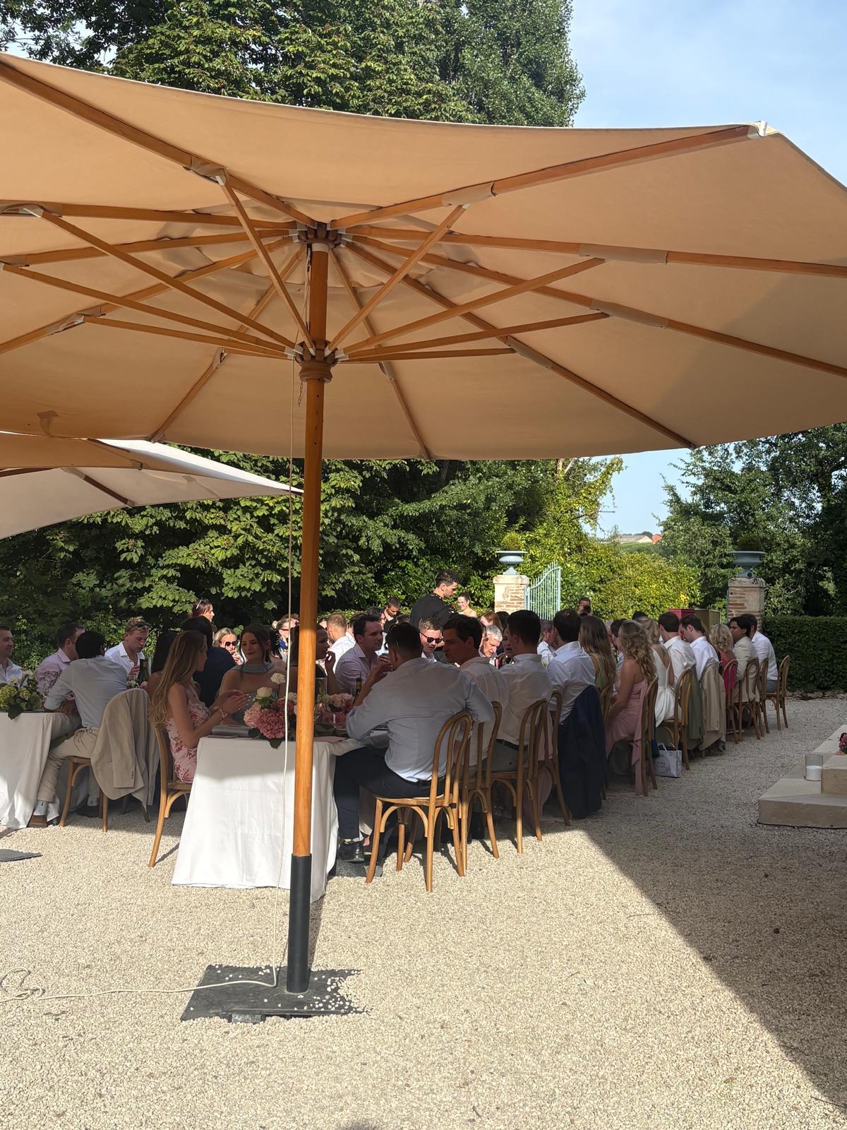 Invités à table sous les parasols, jardin